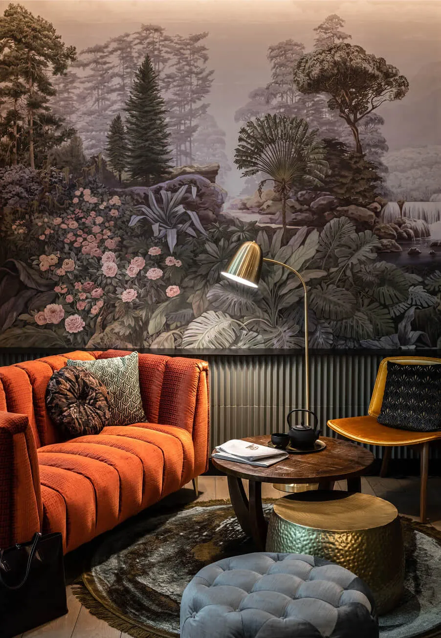 Cozy sitting area with couch and table in front of printed wallpaper