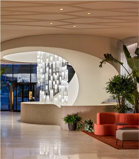 Hotel lobby with orange couch, plants and big chandelier