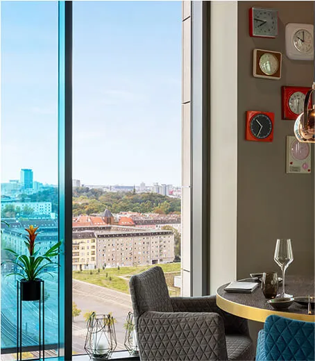 High hotel room with big windows and colourful interior
