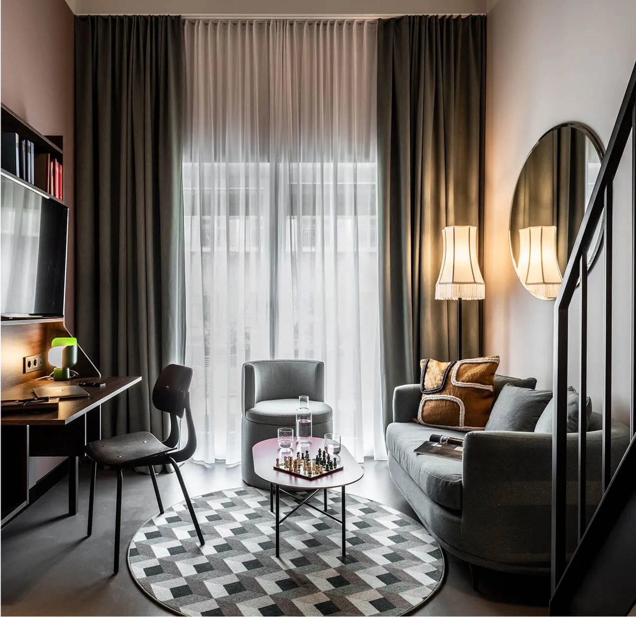 Cozy hotel room with sitting area, chess game and working place