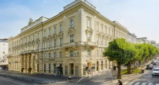 Old beige historical building with trees and bue sky