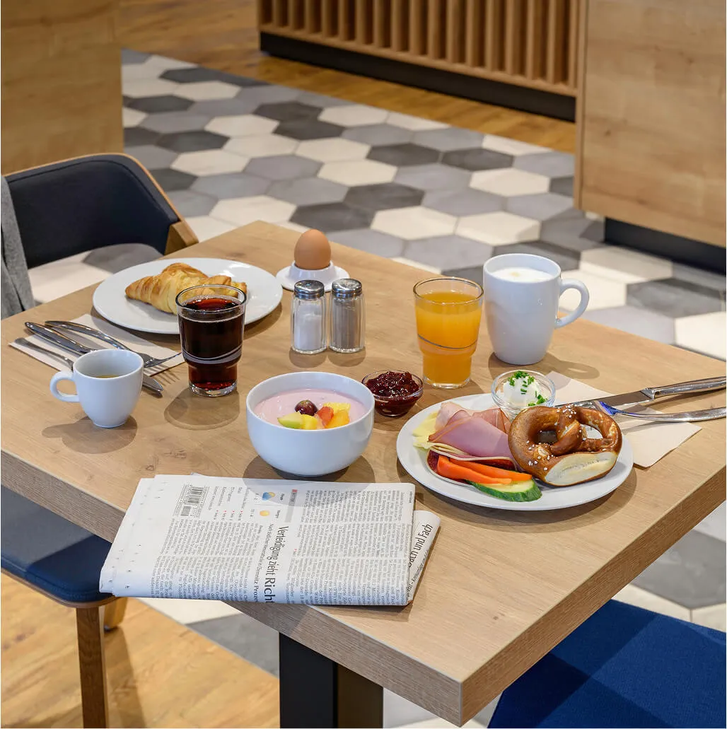Breakfast table with food, newspaper and drinks