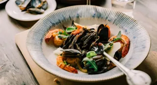 White and blue plate with seafood and fork