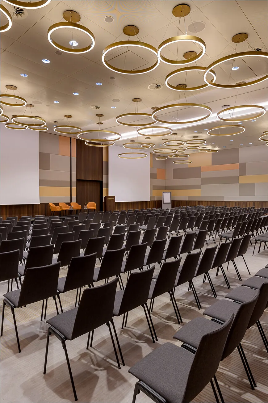 View into meeting room full of chairs and round daylight lamps
