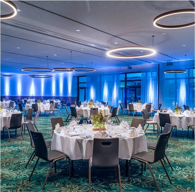 Banquet room with round tables and dinner preparation