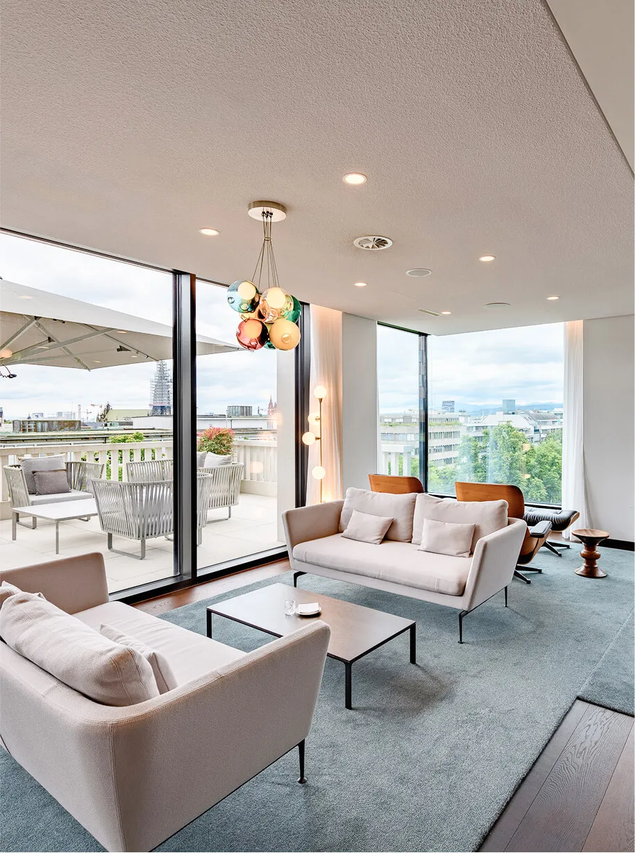 Sitting area with couches and stools on grey carpet with cityview