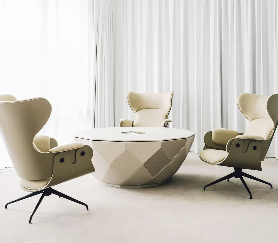 Three beige designer stools and a round table