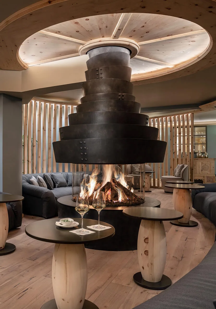 Modern open fireplace in hotel lobby with wooden interior
