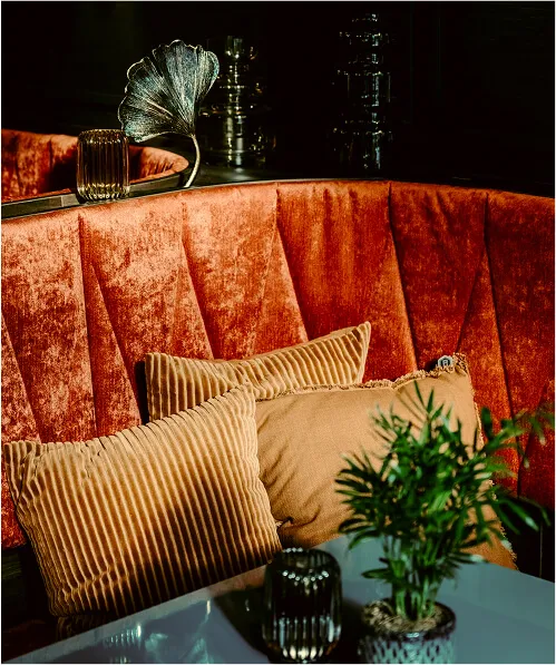White armchair and table in front of windowfront with cityview