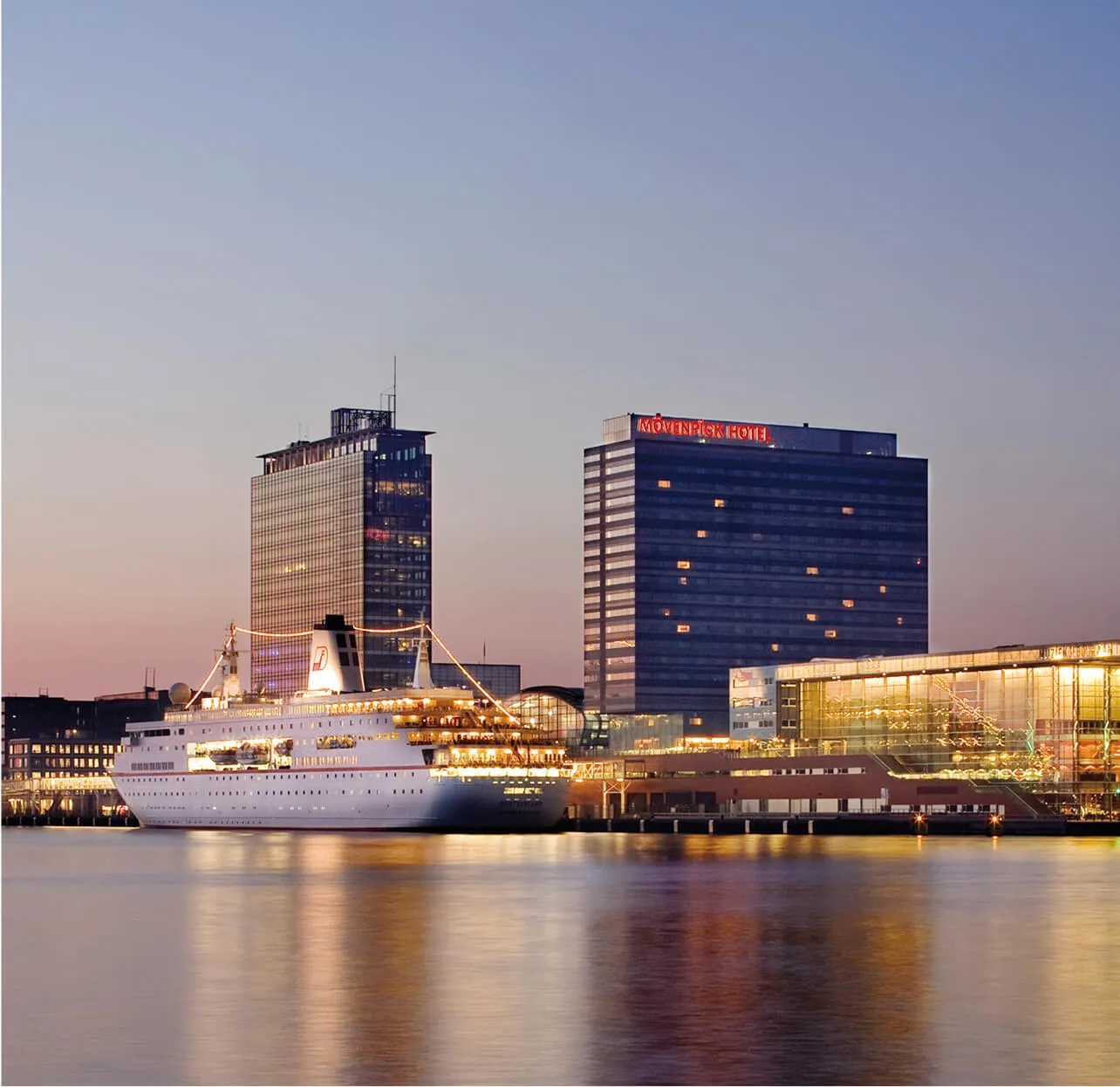 hotel building with canal and ship in front
