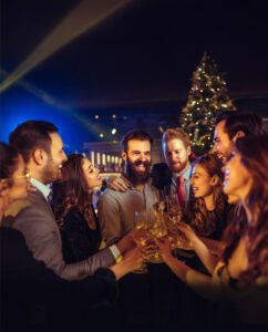 Feiern Sie Weihnachten – und Ihr Team Eine Menschengruppe, die ausgelassen feiert